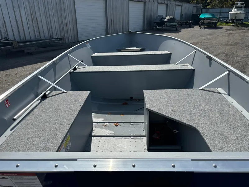 Slide: The Image of 2025 Crestliner 1672 Outlook boat interior, featuring spacious seating and storage, parked outdoors. - 7