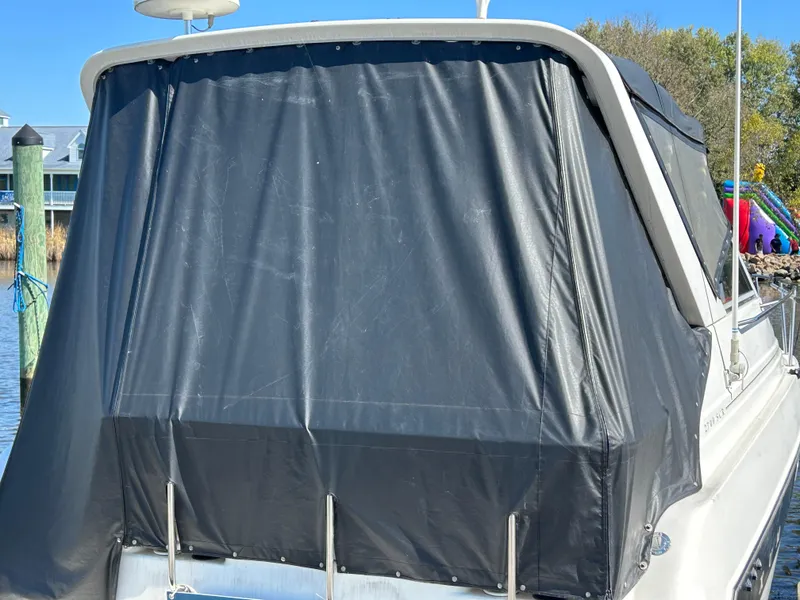 Slide: The Image of 1993 Maxum 2700 SCR boat with black canvas cover docked at marina. - 3