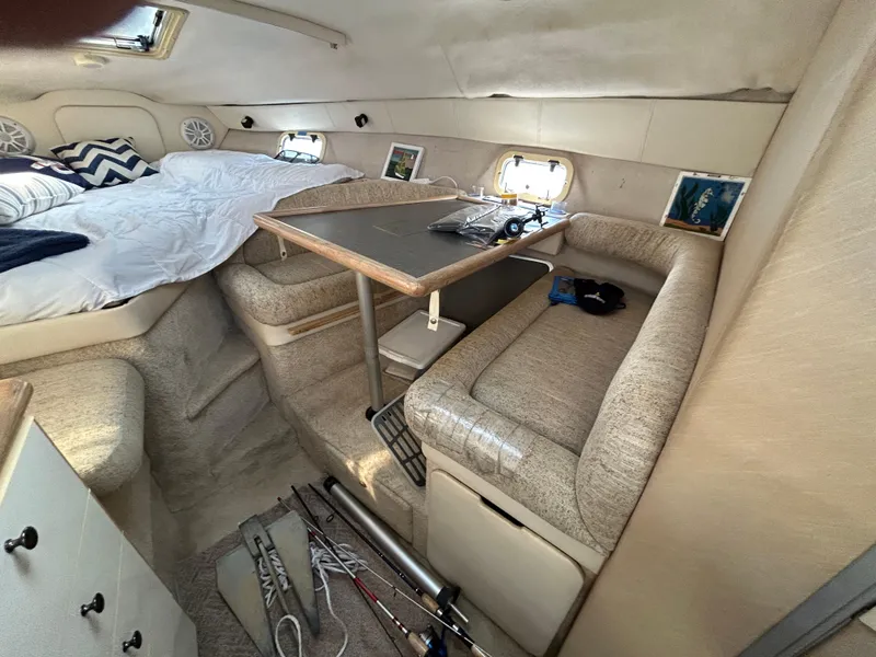 Slide: The Image of Interior of a 1993 Maxum 2700 SCR boat with cozy seating and a small table. - 8