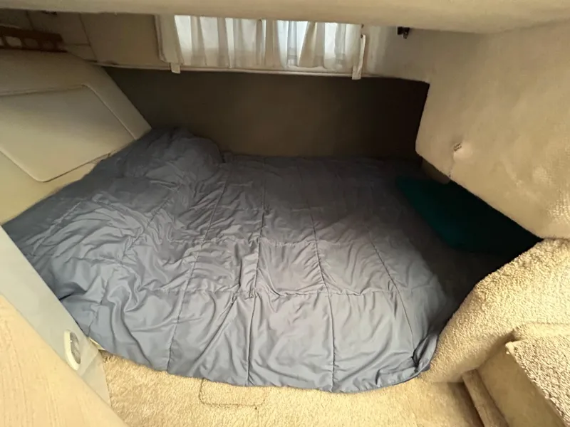 Slide: The Image of Cozy sleeping area in a 1993 Maxum 2700 SCR boat cabin with blue bedding. - 9