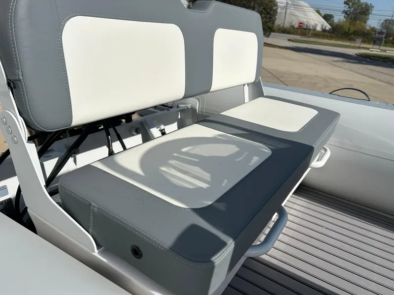 Slide: The Image of 2024 Highfield Classic 420 boat seat, gray and white upholstery, outdoor setting. - 12
