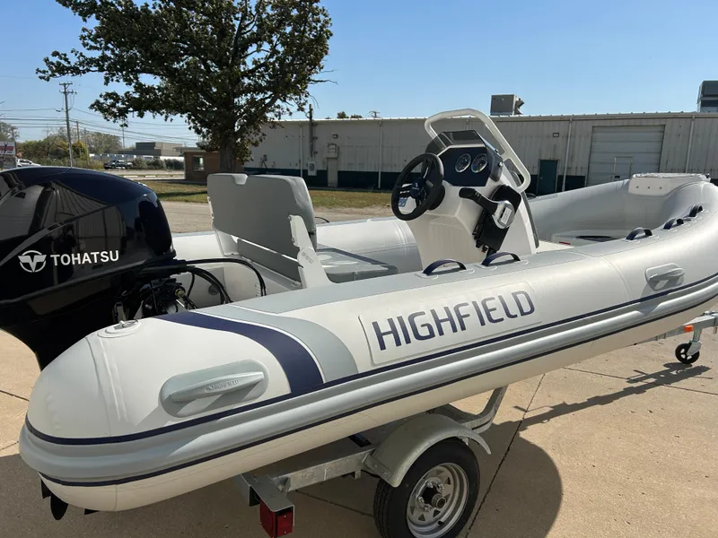 Slide: The Image of 2024 Highfield Classic 420 inflatable boat with Tohatsu engine on trailer. - 2