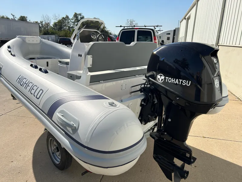 Slide: The Image of 2024 Highfield Classic 420 boat with Tohatsu outboard motor, parked outdoors. - 3
