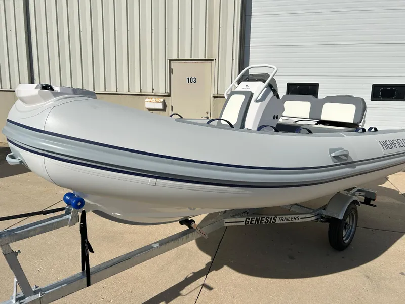 Slide: The Image of 2024 Highfield Classic 420 inflatable boat on Genesis trailer, parked outdoors. - 8