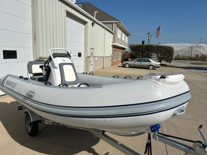 Slide: The Image of 2024 Highfield Classic 420 inflatable boat on trailer, parked outside a building. - 9