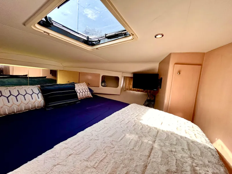 Slide: The Image of Luxurious cabin interior of 1999 Carver Voyager 370 yacht with skylight and cozy bedding. - 20