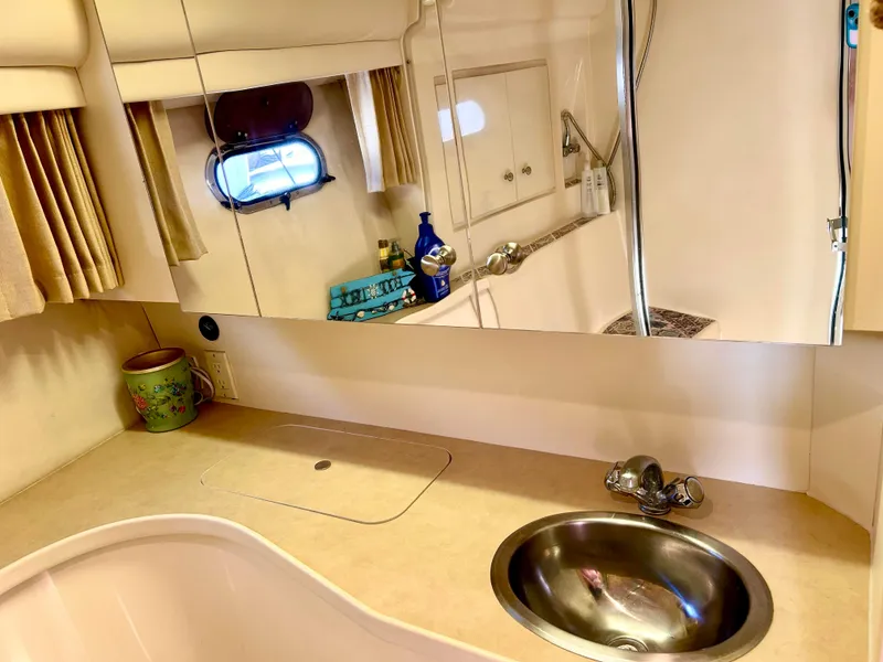 Slide: The Image of 1999 Carver Voyager 370 bathroom with sink, mirror, and porthole window. - 25