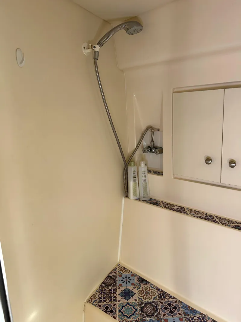 Slide: The Image of Shower area in 1999 Carver Voyager 370 with decorative tiles and storage cabinets. - 26
