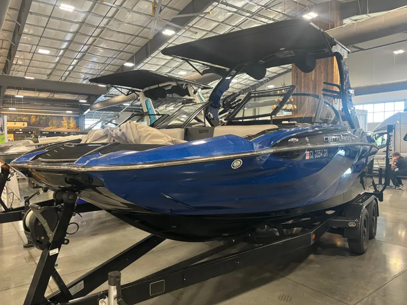 Slide: The Image of 2020 Centurion Fi21 boat displayed indoors on a trailer, featuring a sleek blue design. - 2