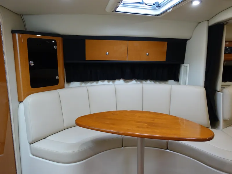 Slide: The Image of 2008 Chaparral Signature 330 interior with curved seating and wooden table. - 13