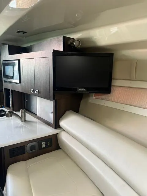 Slide: The Image of Interior of 2017 Monterey 295 Sport Yacht with TV, microwave, and seating area. - 11
