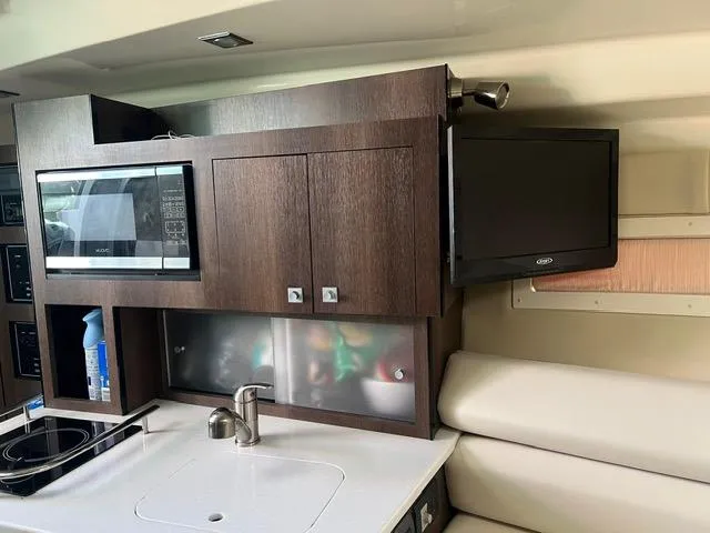 Slide: The Image of Interior of 2017 Monterey 295 Sport Yacht with kitchenette, microwave, and TV. - 16