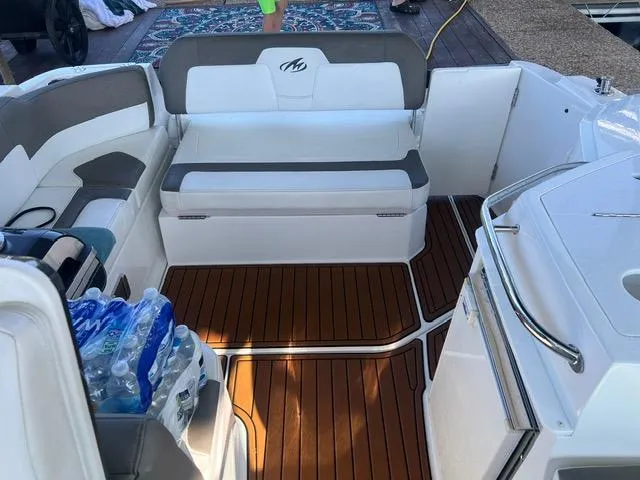 Slide: The Image of 2017 Monterey 295 Sport Yacht interior with seating, wooden flooring, and water bottles. - 22