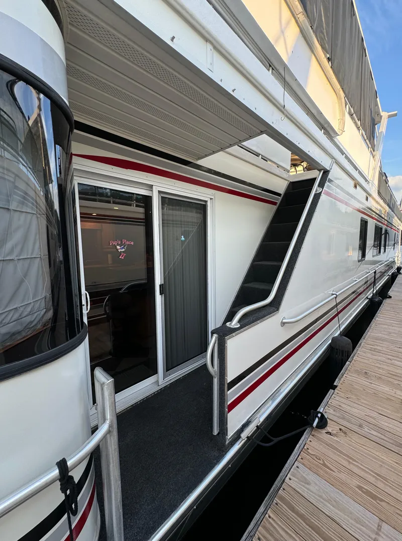 Slide: The Image of 2004 Sumerset 20x100 houseboat exterior with sliding glass door and staircase. - 2