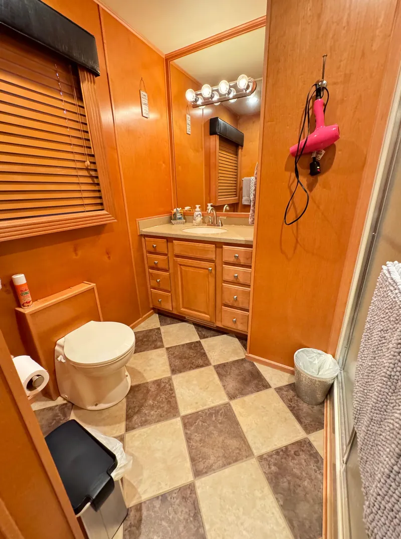 Slide: The Image of 2004 Sumerset 20x100 bathroom with wood paneling, checkered floor, and vanity mirror. - 33