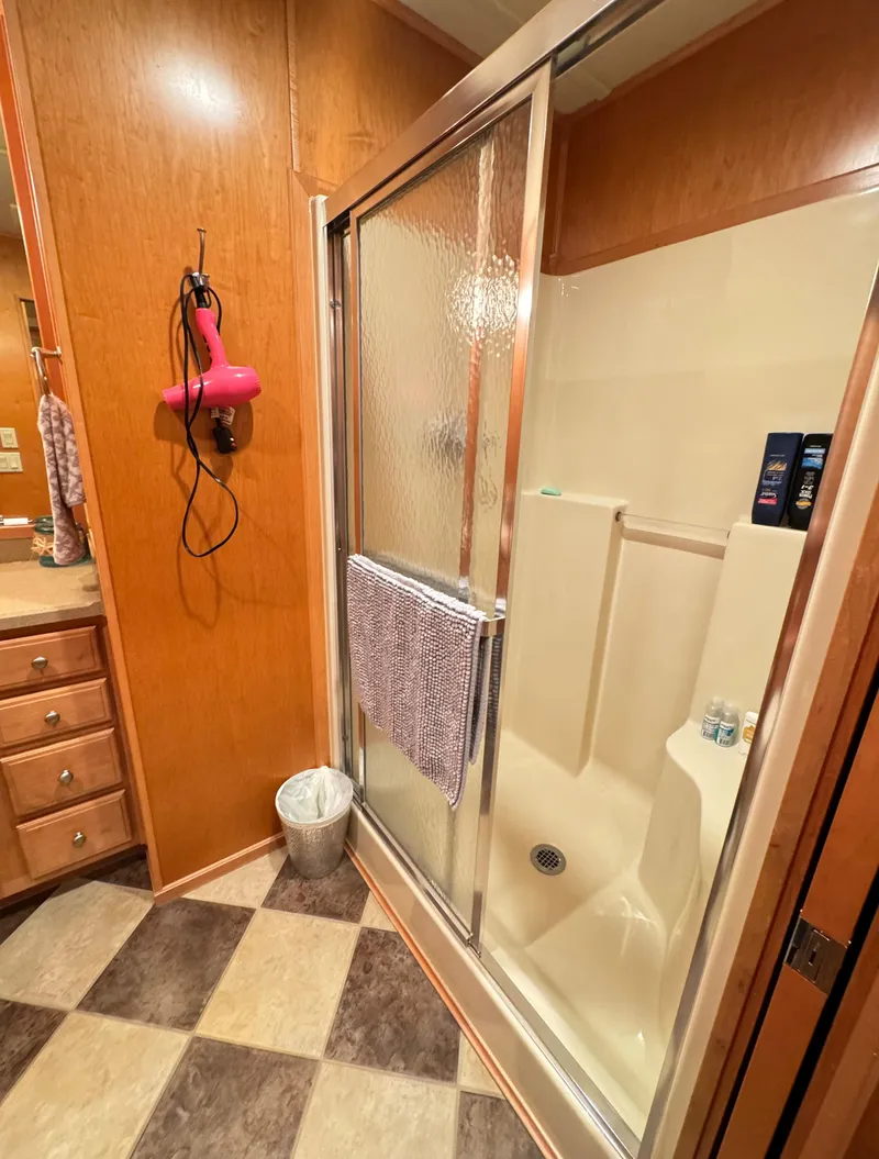 Slide: The Image of 2004 Sumerset 20x100 bathroom with shower, wood paneling, and checkered floor. - 34