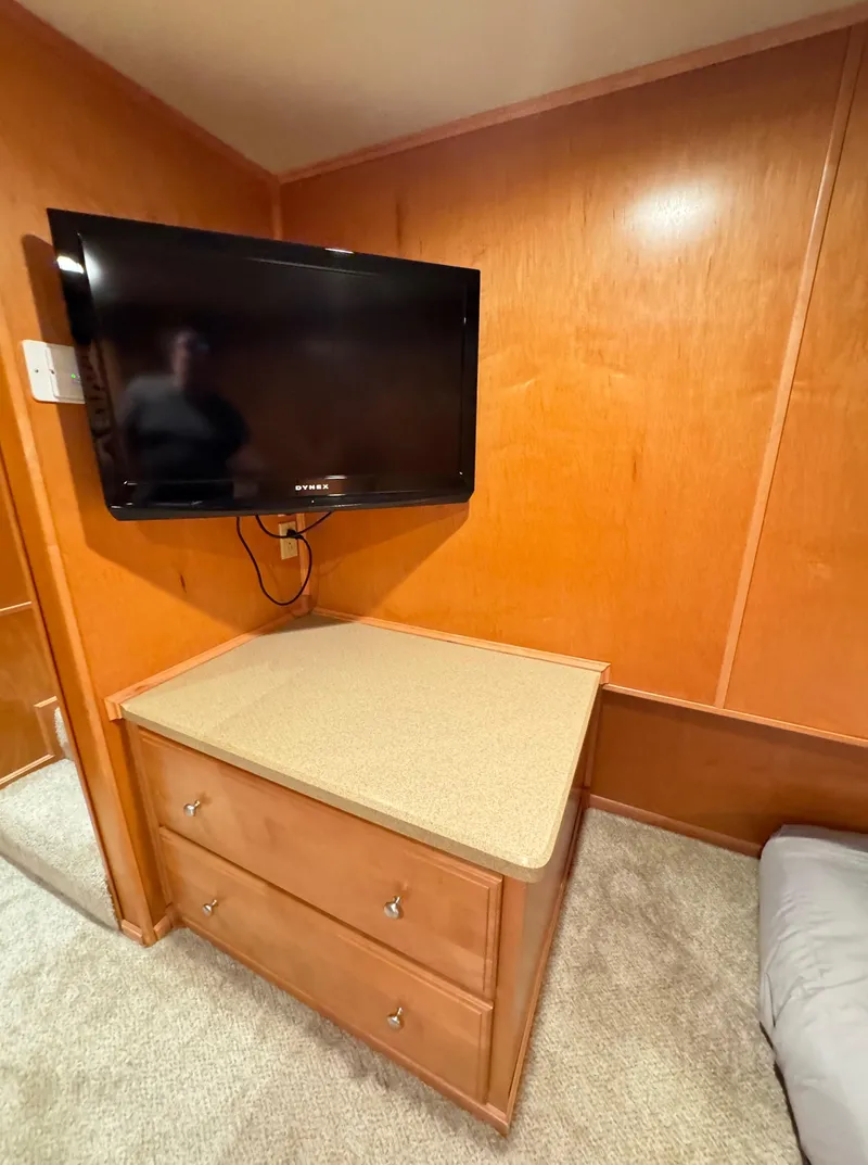 Slide: The Image of 2004 Sumerset 20x100 interior with mounted TV and wooden dresser. - 45