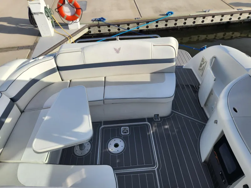Slide: The Image of 2002 Formula 37 PC boat interior with white seating and table at dock. - 13