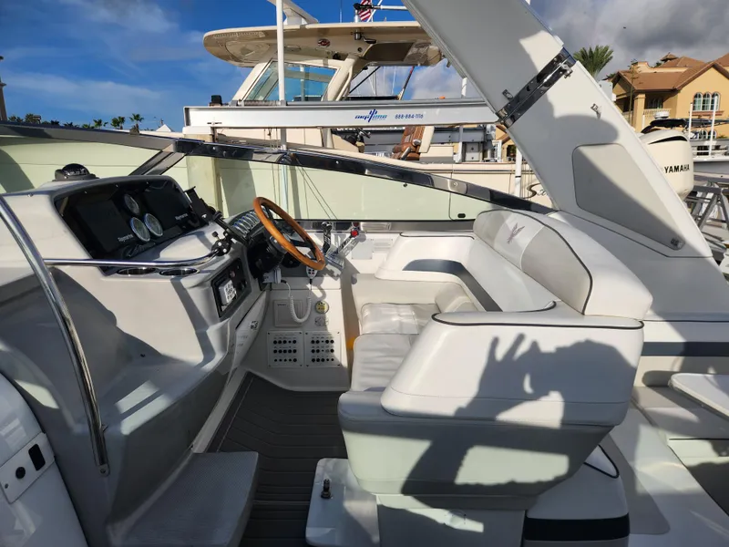 Slide: The Image of 2002 Formula 37 PC yacht cockpit with white seating and steering wheel, docked under clear skies. - 17