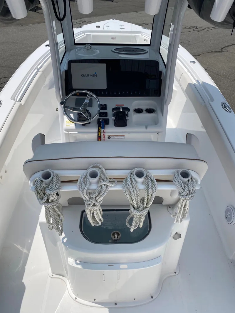 Slide: The Image of 2020 Sea Hunt Gamefish 25 boat cockpit with steering wheel, Garmin display, and rope holders. - 11