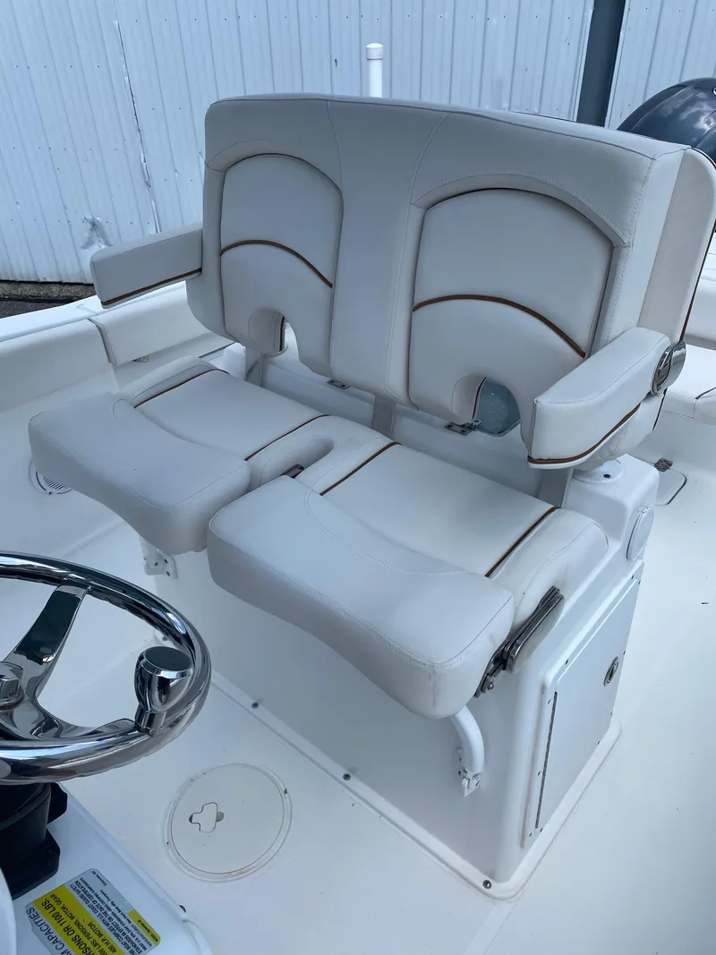 Slide: The Image of 2020 Sea Hunt Gamefish 25 boat seats with white upholstery and steering wheel. - 12