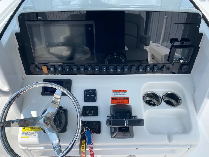 Slide: The Image of Control panel of a 2020 Sea Hunt Gamefish 25 boat with steering wheel and electronics. - 14