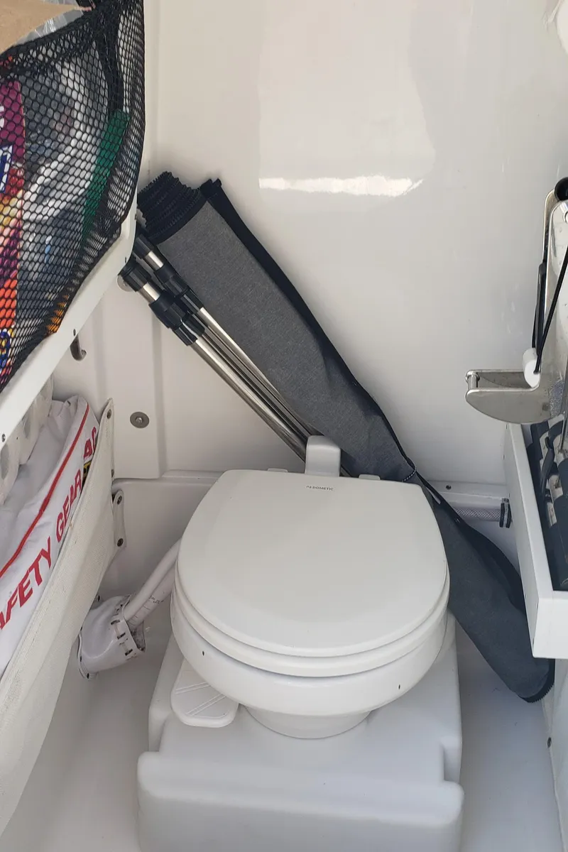 Slide: The Image of 2020 Sea Hunt Gamefish 25 boat interior with toilet and safety gear. - 18