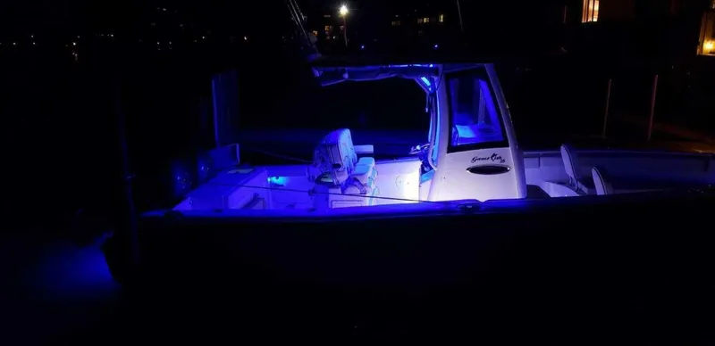 Slide: The Image of 2020 Sea Hunt Gamefish 25 boat illuminated by blue lights at night. - 22