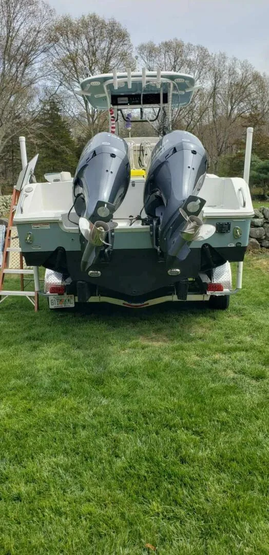 Slide: The Image of 2020 Sea Hunt Gamefish 25 boat with dual outboard motors on grass. - 25