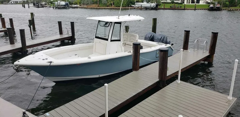 Slide: The Image of 2020 Sea Hunt Gamefish 25 boat docked on a calm waterfront. - 3