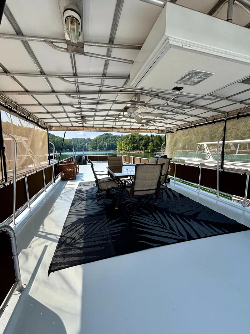 Slide: The Image of Spacious deck on 2012 Horizon 16x66 houseboat with outdoor seating and scenic lake view. - 12