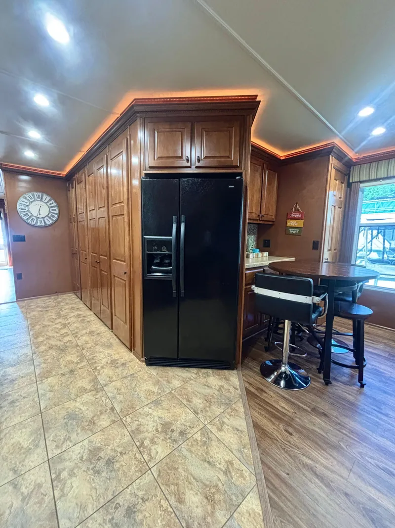 Slide: The Image of Modern kitchen interior in 2012 Horizon 16x66, featuring wood cabinets and black refrigerator. - 25