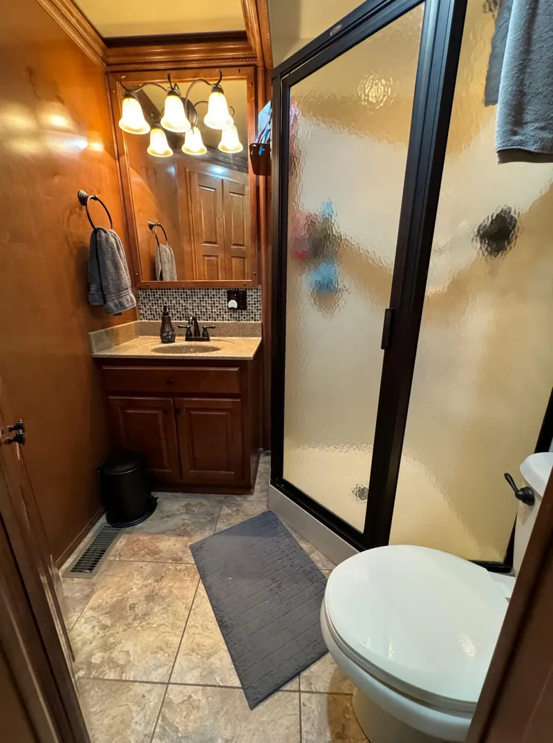 Slide: The Image of Compact bathroom with shower, wooden cabinetry, and modern lighting in a 2012 Horizon 16x66 model. - 37