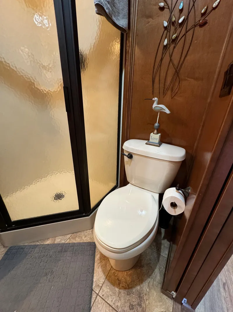 Slide: The Image of Bathroom with shower, toilet, and decorative wall art in 2012 Horizon 16x66 model. - 39