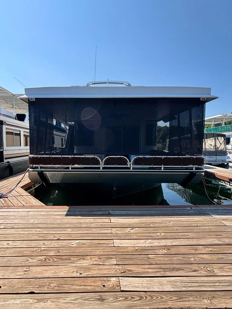 Slide: The Image of 2012 Horizon 16x66 houseboat docked at a marina under clear blue skies. - 4
