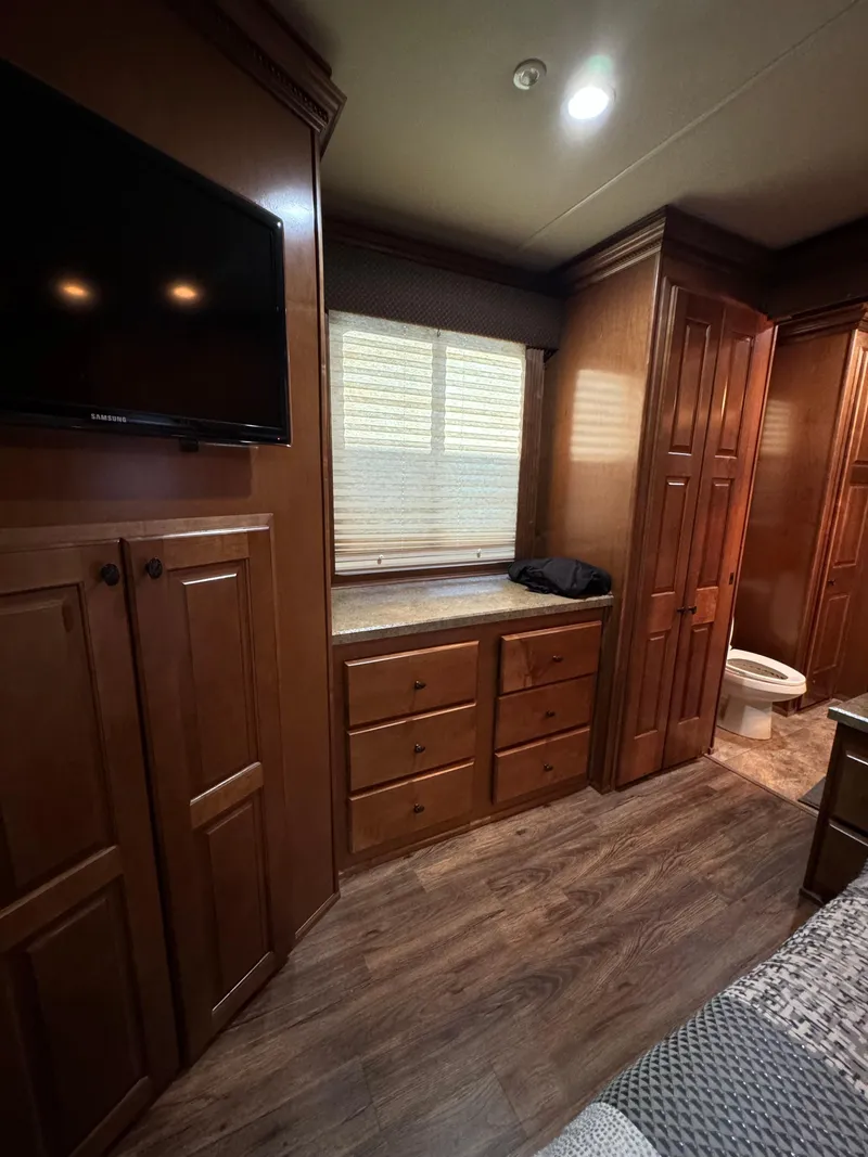 Slide: The Image of 2012 Horizon 16x66 interior with wood cabinets, TV, and window. - 45