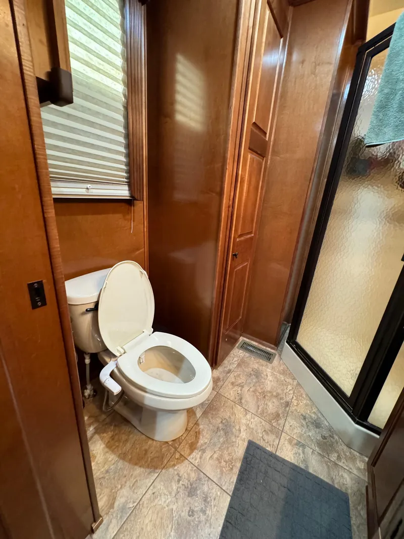 Slide: The Image of 2012 Horizon 16x66 bathroom with toilet, shower, and wooden cabinetry. - 47