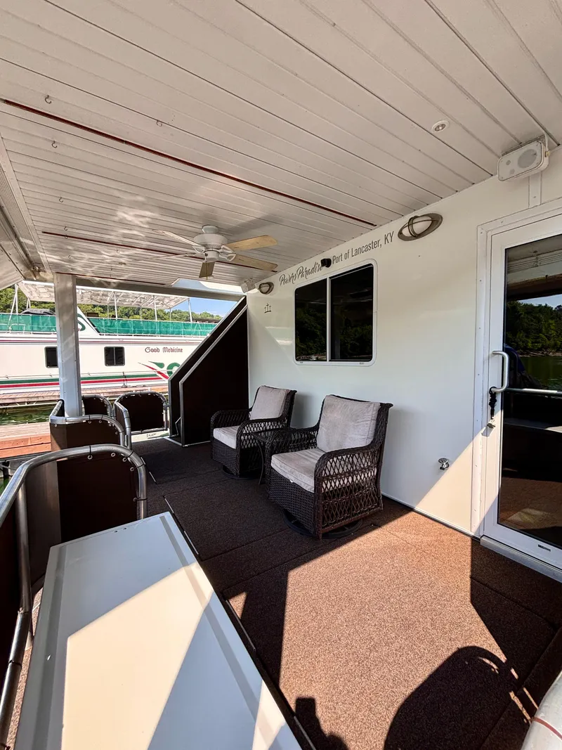 Slide: The Image of Houseboat deck with wicker chairs, ceiling fan, and "Port of Lancaster, KY" sign. Horizon 16x66, 2012. - 8