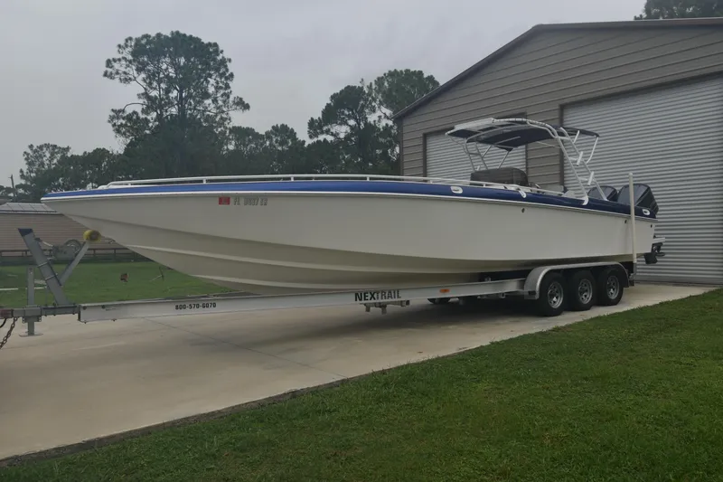 Slide: The Image of 1984 Chris-Craft Scorpion boat on trailer, parked near a garage. - 2