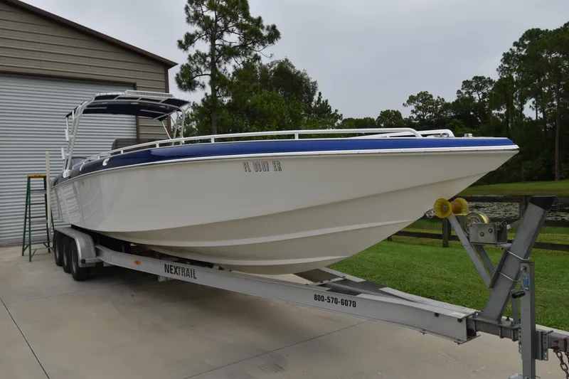 Slide: The Image of 1984 Chris-Craft Scorpion boat on trailer near garage and trees. - 4