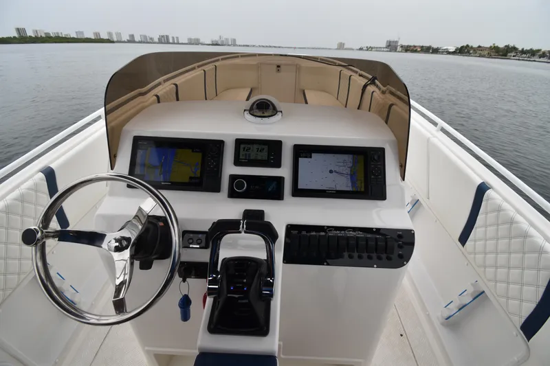 Slide: The Image of 1984 Chris-Craft Scorpion boat dashboard with steering wheel and navigation screens on open water. - 5