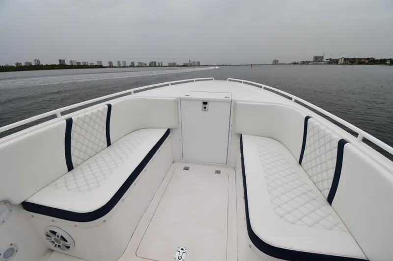 Slide: The Image of 1984 Chris-Craft Scorpion boat interior with white cushioned seating on a calm water backdrop. - 6