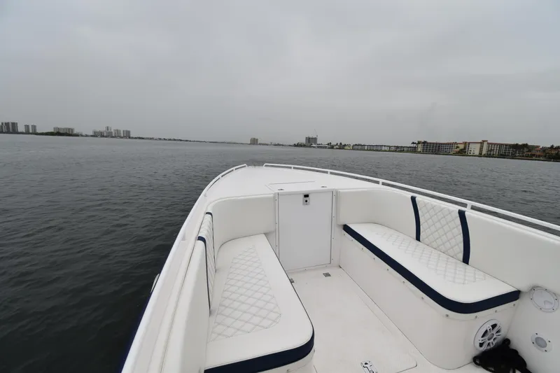 Slide: The Image of 1984 Chris-Craft Scorpion boat interior with white seating on a calm waterway. - 8