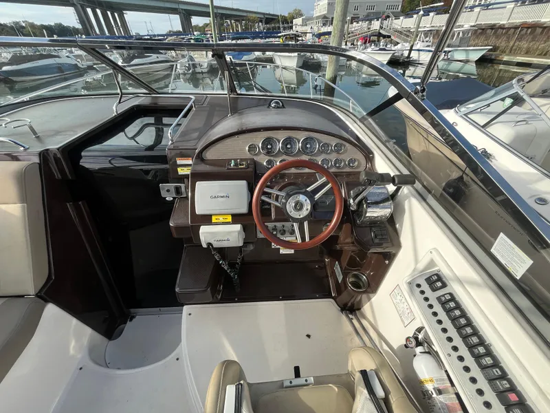 Slide: The Image of 2013 Regal 30 Express boat cockpit with steering wheel and control panel. - 10