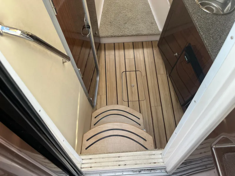 Slide: The Image of Interior view of 2013 Regal 30 Express boat with wooden flooring and compact kitchenette. - 15