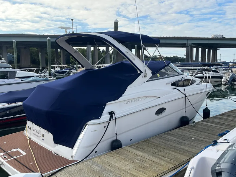 Slide: The Image of 2013 Regal 30 Express boat docked at marina under blue cover. - 2