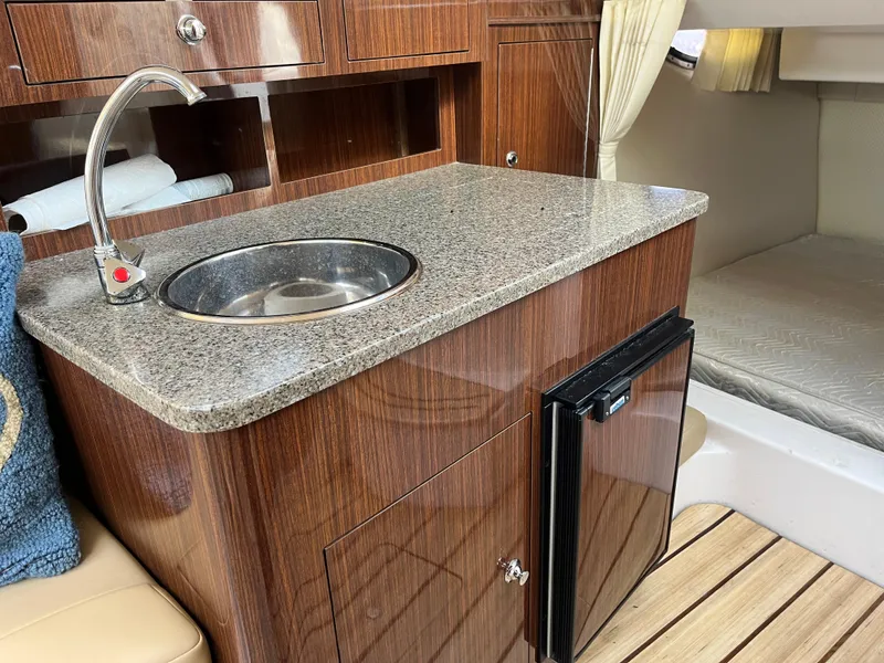 Slide: The Image of 2013 Regal 30 Express yacht interior with kitchenette, sink, and mini fridge. - 20