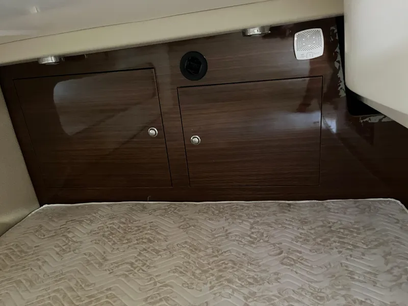 Slide: The Image of 2013 Regal 30 Express cabin interior with wood paneling and storage compartments. - 25