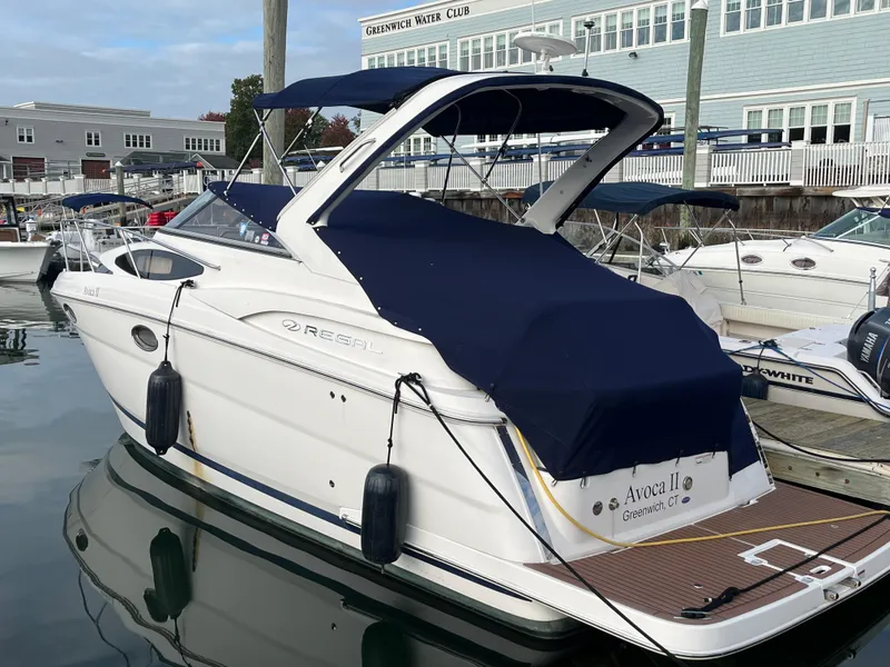 Slide: The Image of 2013 Regal 30 Express boat docked at marina with blue cover. - 3