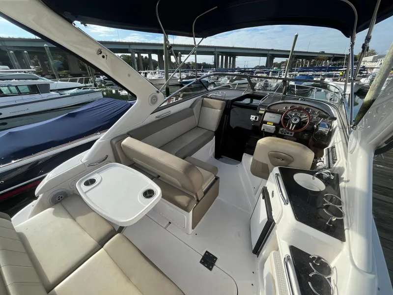 Slide: The Image of 2013 Regal 30 Express boat interior with seating, table, and helm, docked at marina. - 5